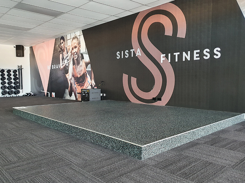 Platform with rubber flooring in group fitness area in gym
