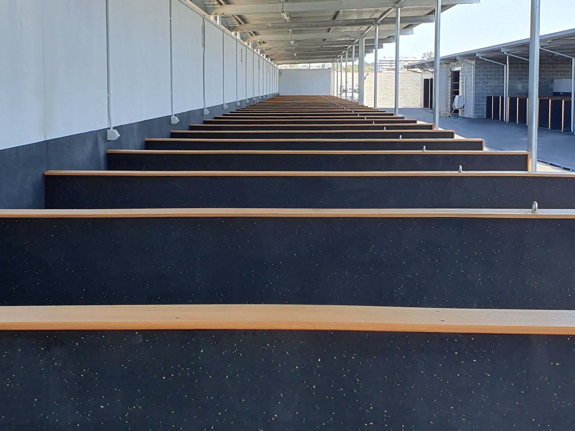 Equine rubber flooring lining open horse stalls at Belmont Park Racecourse
