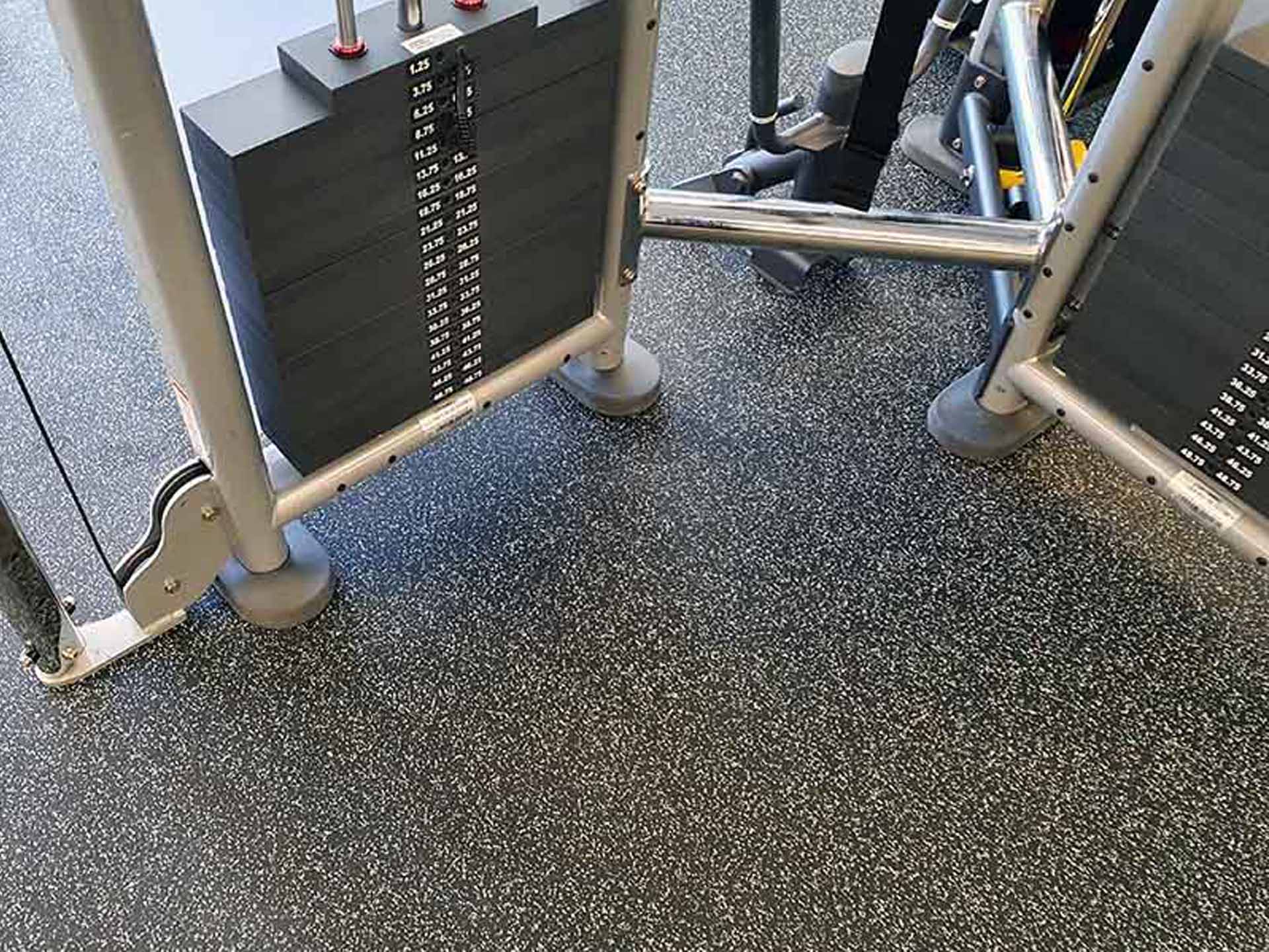 Heavy gym equipment sitting on rubber gym flooring