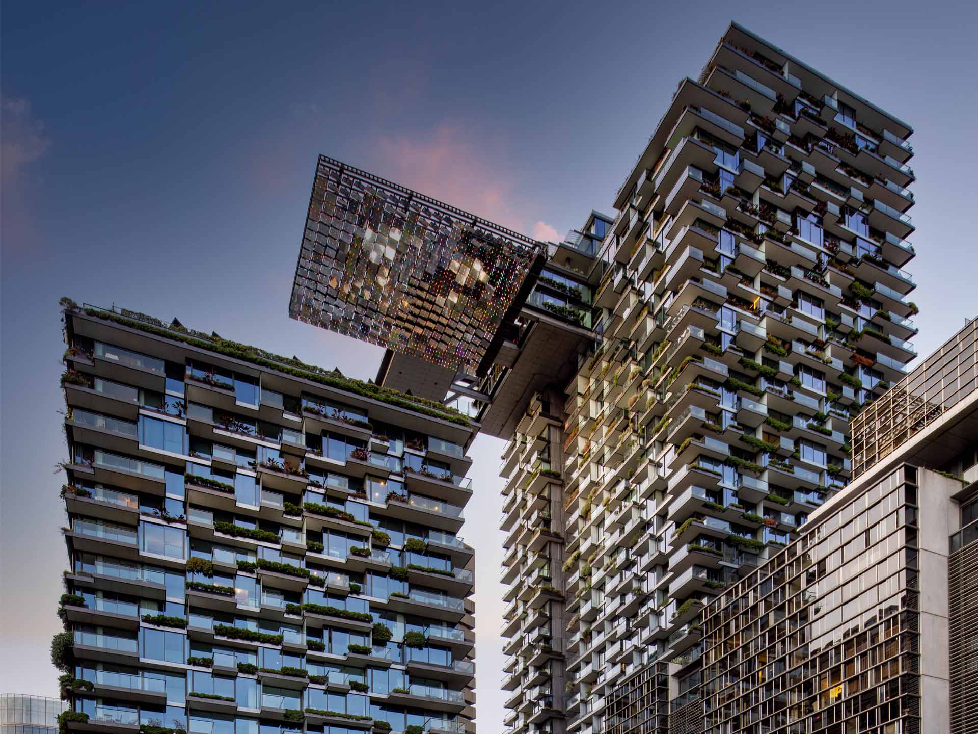 Facade of building that meets green star building standards, with plants on balconies.